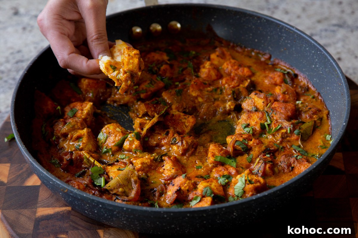 South Indian Black Pepper Tofu Curry with Caramelized Onions 17 dipping flatbread into tofu pepper fry in the skillet