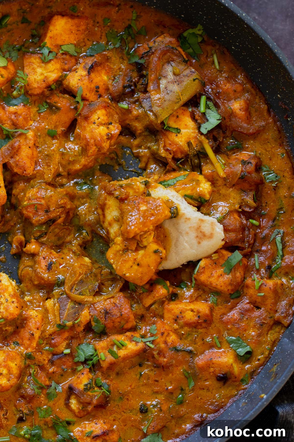 South Indian Black Pepper Tofu Curry with Caramelized Onions 5 close-up of dipping flatbread into tofu pepper fry in the skillet