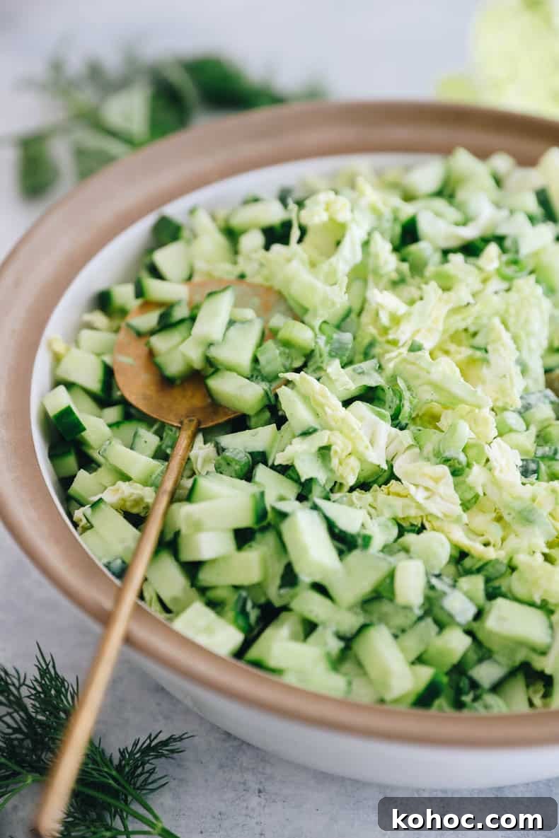 Green Goddess Salad Recipe with Avocado Dressing 5 up close image of cabbage, cucumber, green onion goddess salad topped with a green goddess dressing
