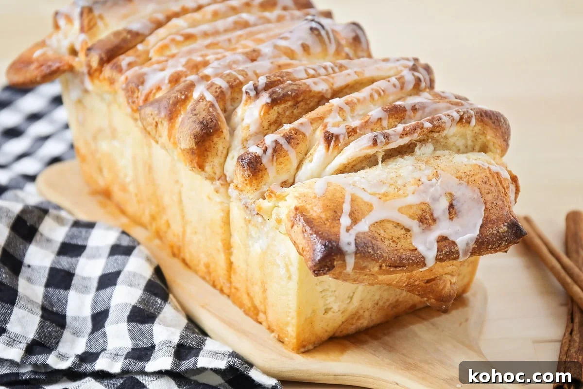 Cinnamon Pull Apart Bread sitting on a cutting board, drizzled with glaze