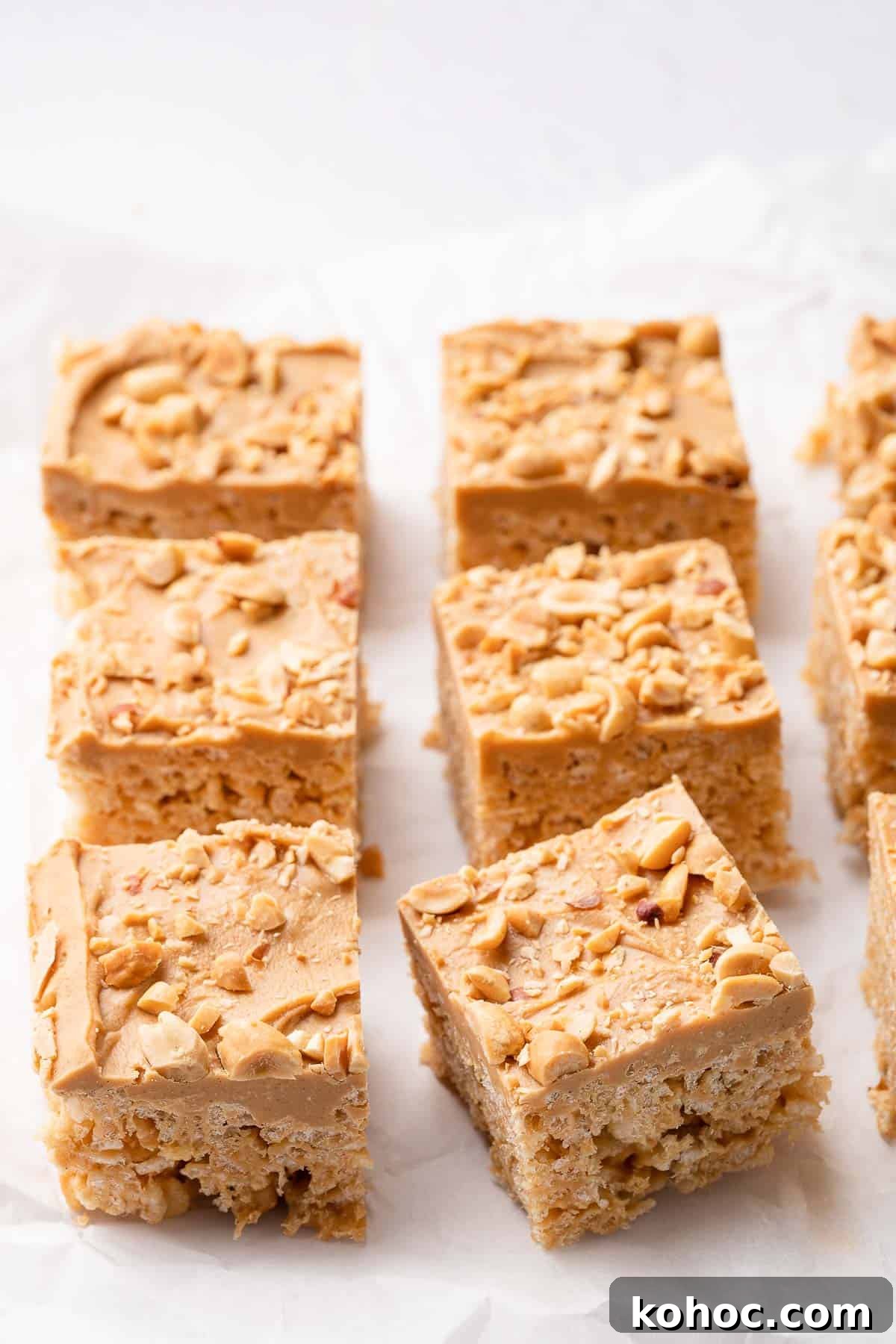 Peanut Butter Rice Krispie Treats Recipe — Chewy No-Bake Bars 5 peanut butter rice krispie treats on parchment paper