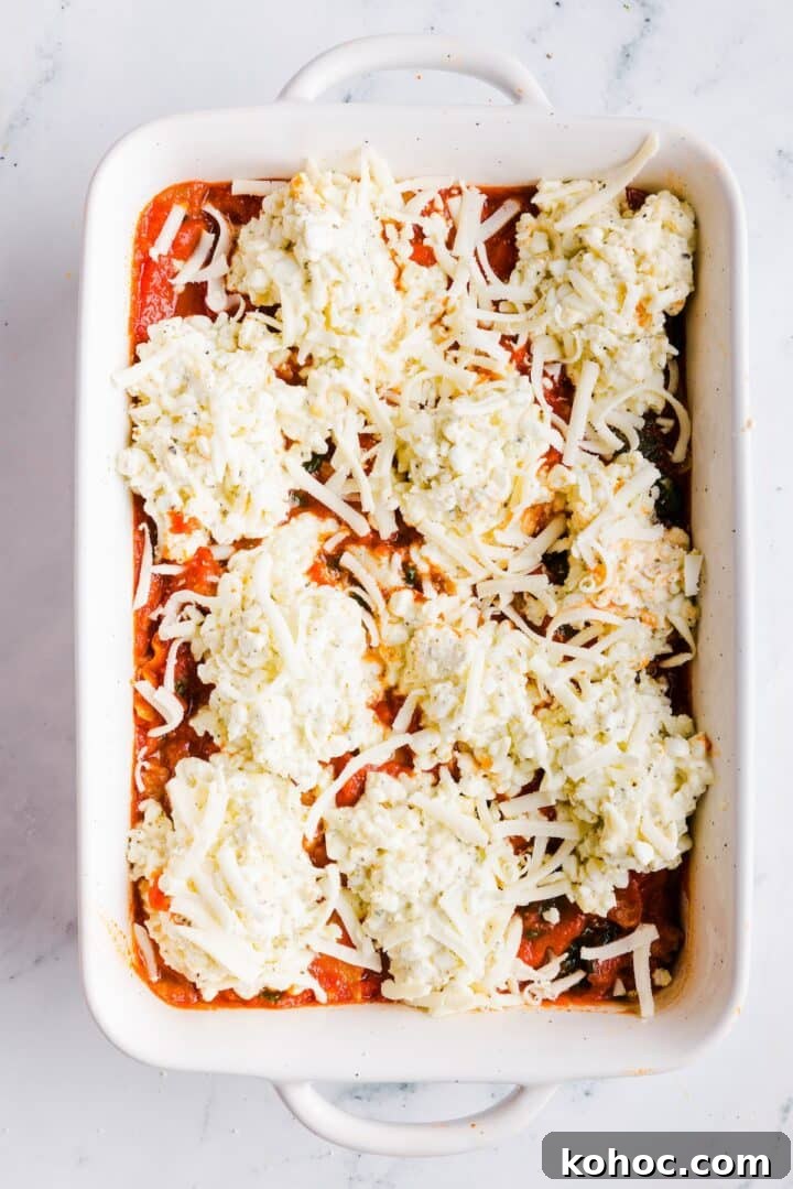 High-Protein Lazy Lasagna Recipe for Quick Meals 11 Cheese covering the top of a high protein lazy lasagna in a large, white baking dish