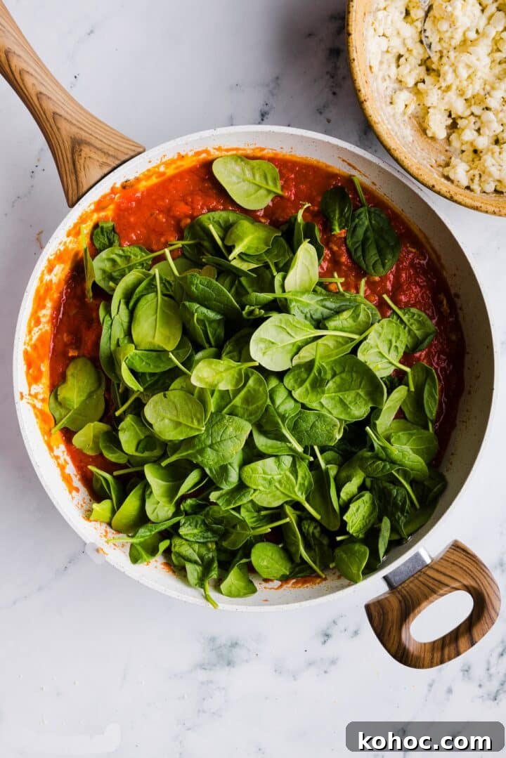 High-Protein Lazy Lasagna Recipe for Quick Meals 8 Spinach added to tomato meat sauce in a large white pot