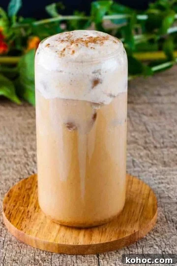 A tall glass of pumpkin cream cold brew garnished with pumpkin pie spice.
