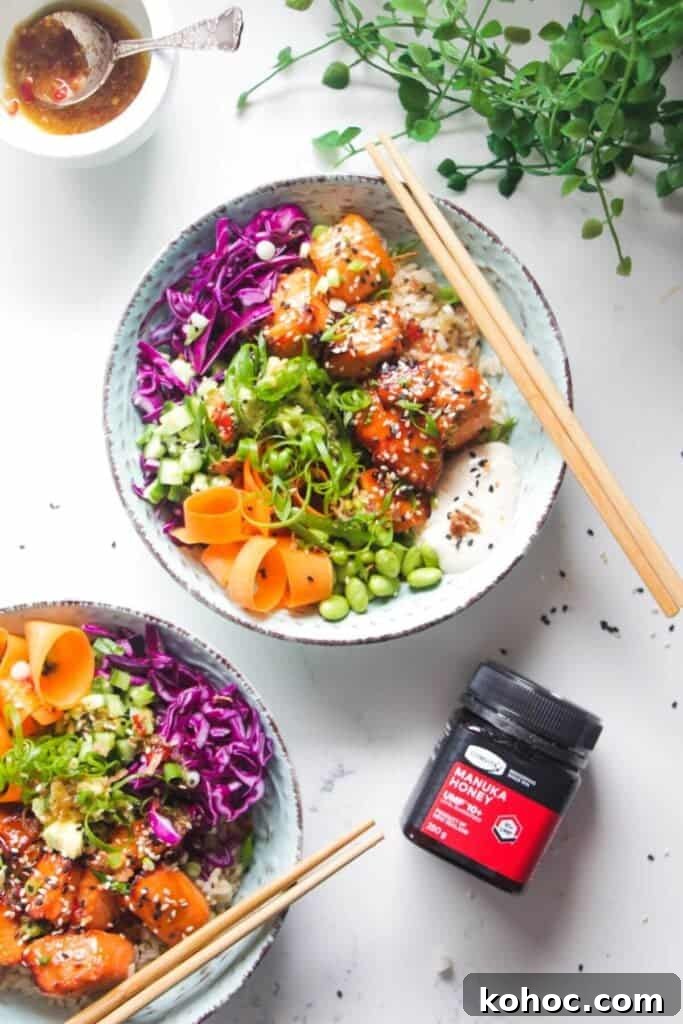 Juicy Chicken Poke Bowl Recipe for Fresh, Flavor-Packed Meals 11 Two baked salmon poke bowls on a marble background with honey on the side.