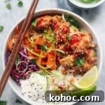 Grilled chicken poke bowl on a grey marble background.