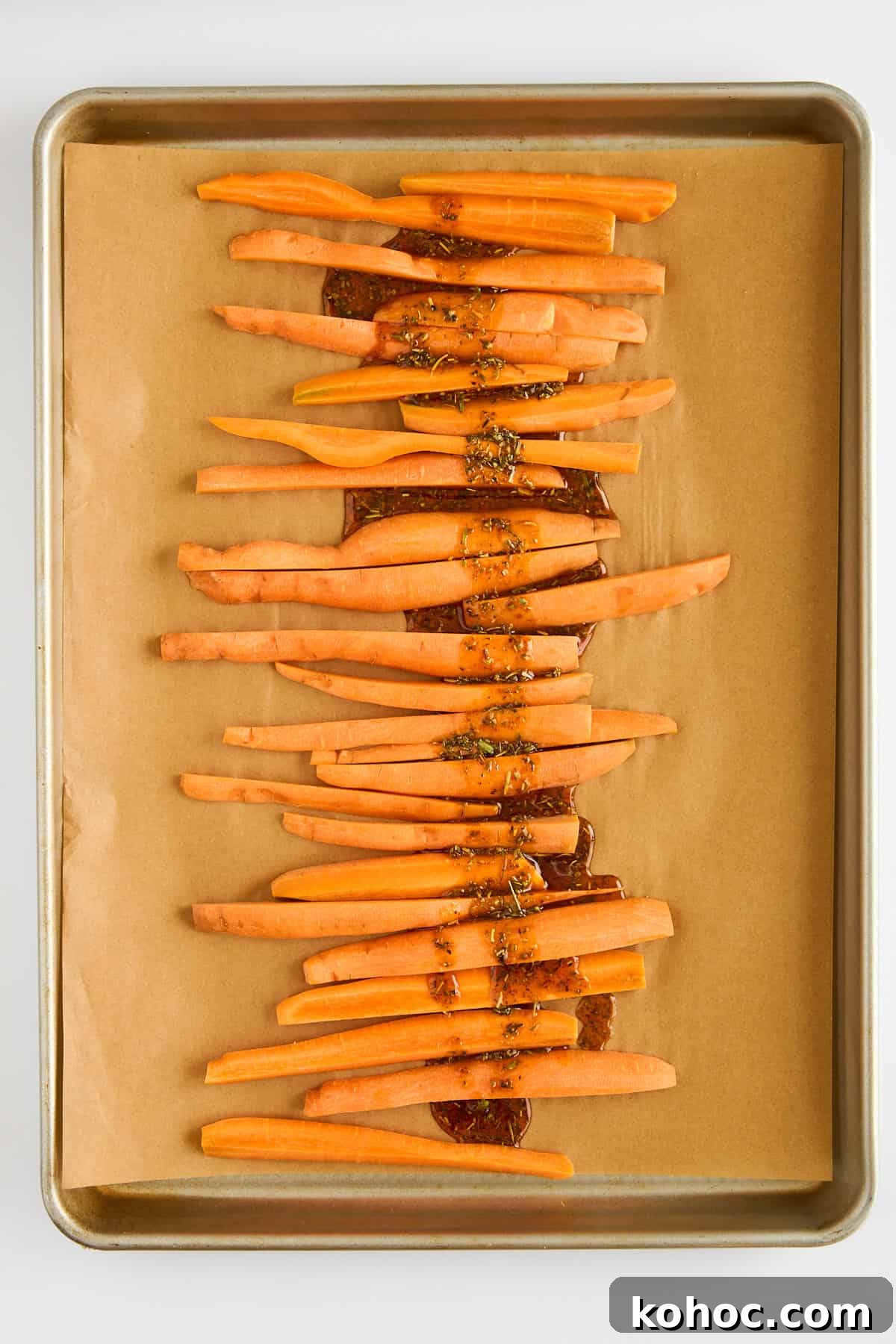 Roasted Carrots & Chickpeas with Creamy Whipped Feta 5 Carrot sticks on a parchment paper lined baking sheet.