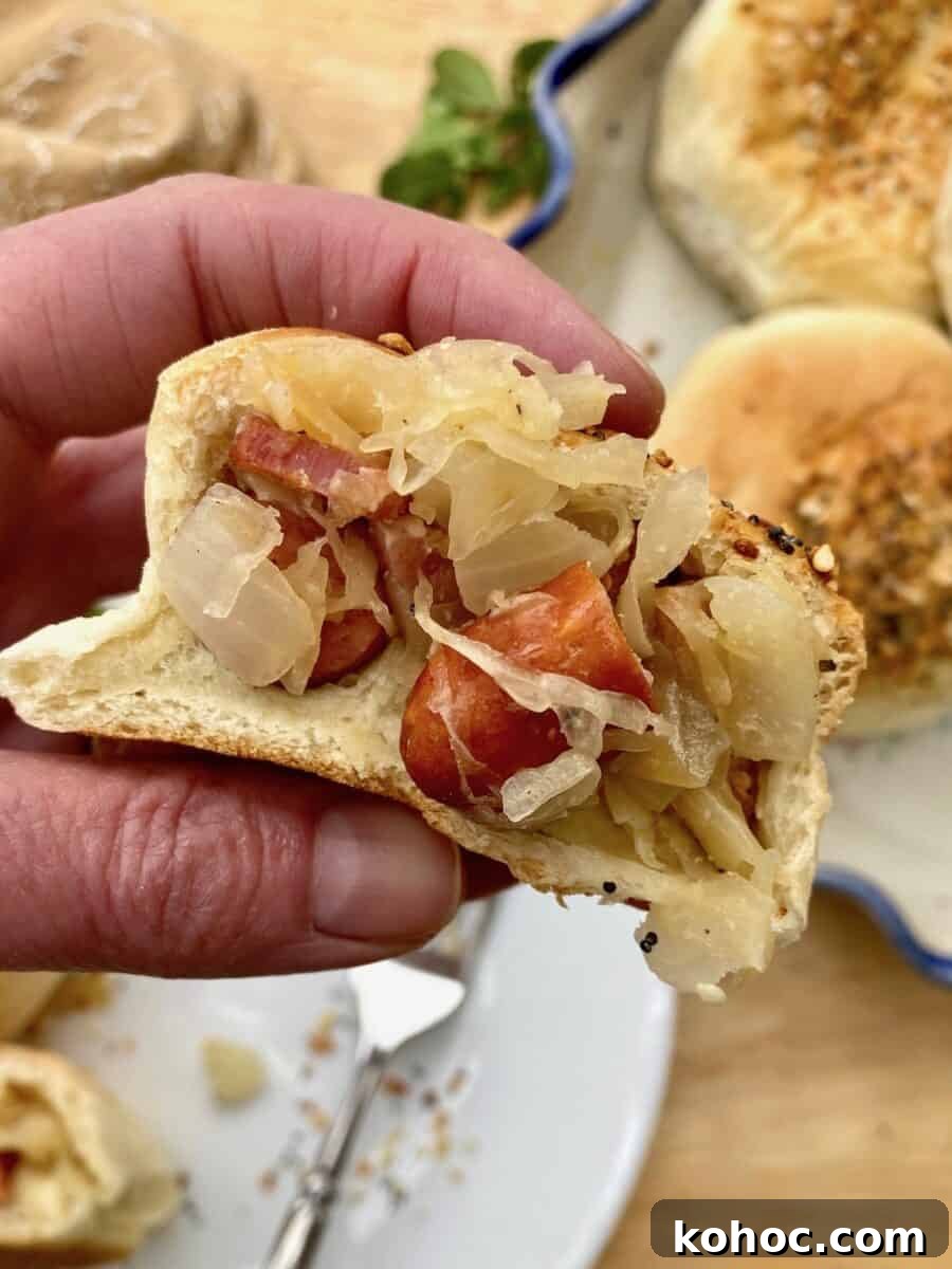 Pig in a blanket cut in half and held in someone's hand