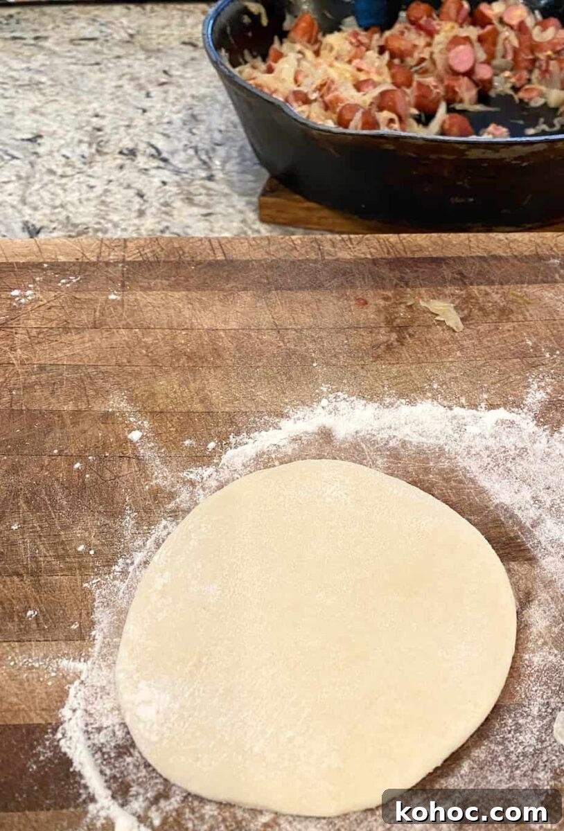 Dough rolled into a circle with a skillet on the side