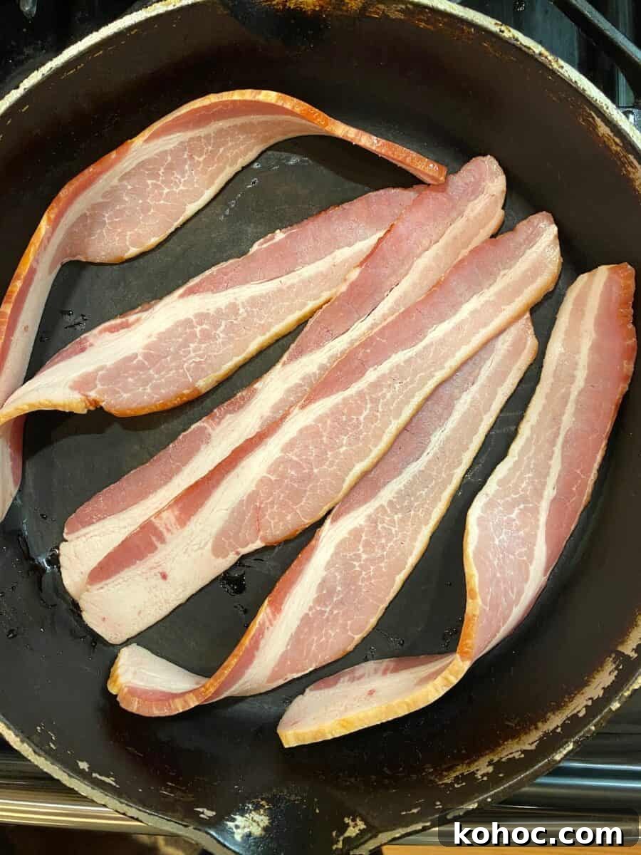 Six slices of bacon in a cast iron skillet