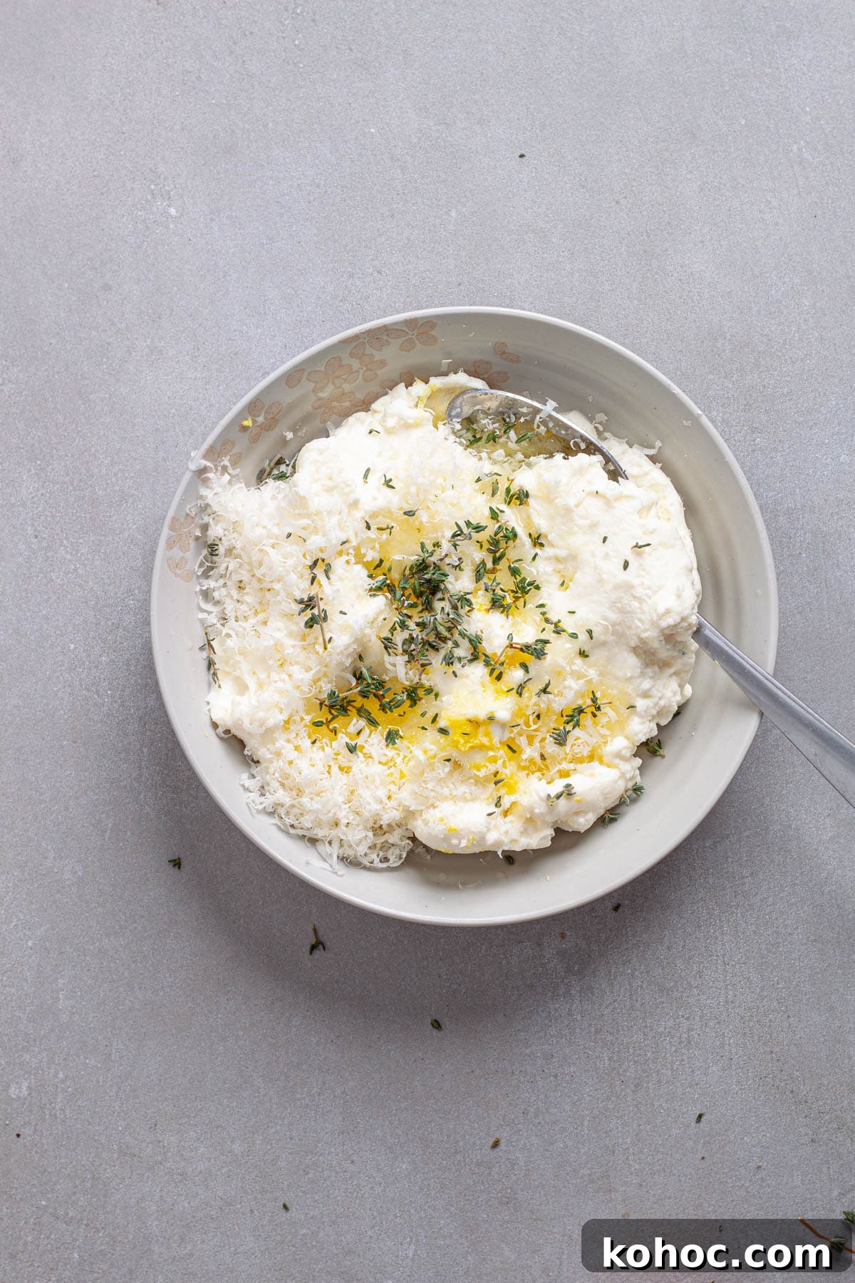 Creamy Baked Ricotta Pesto Pasta with Golden Parmesan Crust 5 Ricotta cheese with herbs and lemon juice in a small bowl.