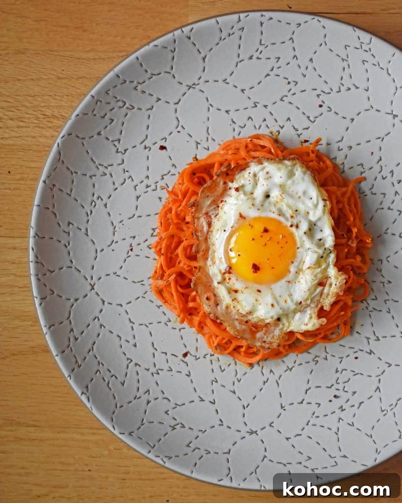 An overhead shot of Sweet Potato Hash with Fried Eggs on a white plate.