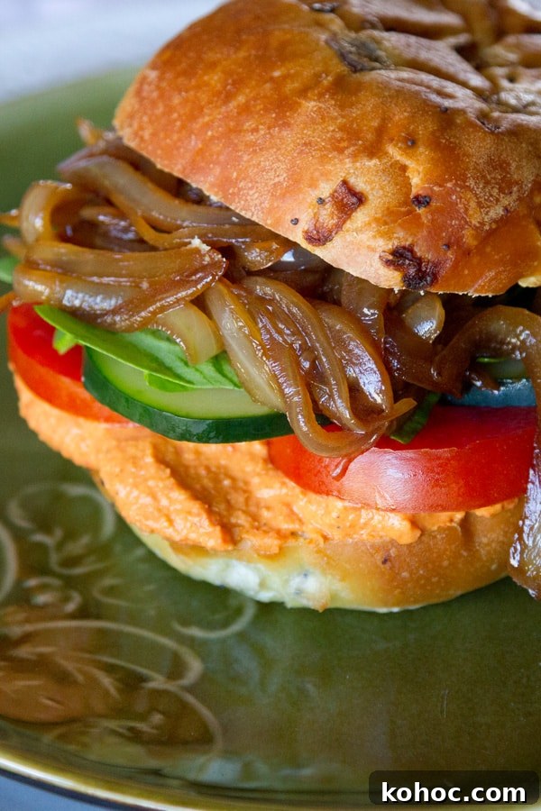 Roasted Red Pepper Hummus Sandwich Recipe for Flavorful Lunch 4 close up on a vegetarian sandwich on an onion bun.