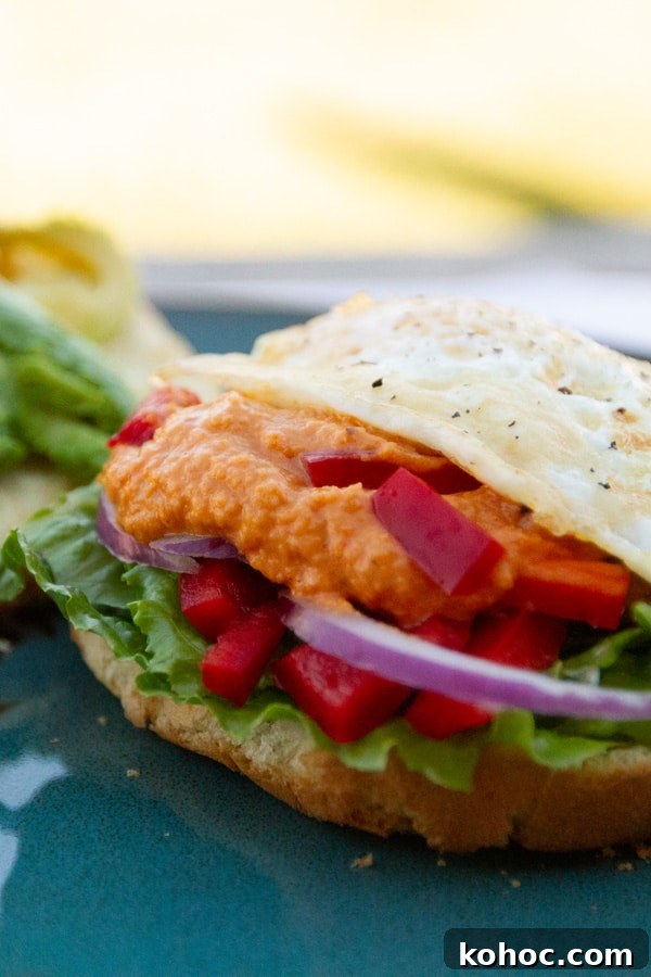 Roasted Red Pepper Hummus Sandwich Recipe for Flavorful Lunch 7 a red pepper hummus sandwich with a fried egg and red onion.