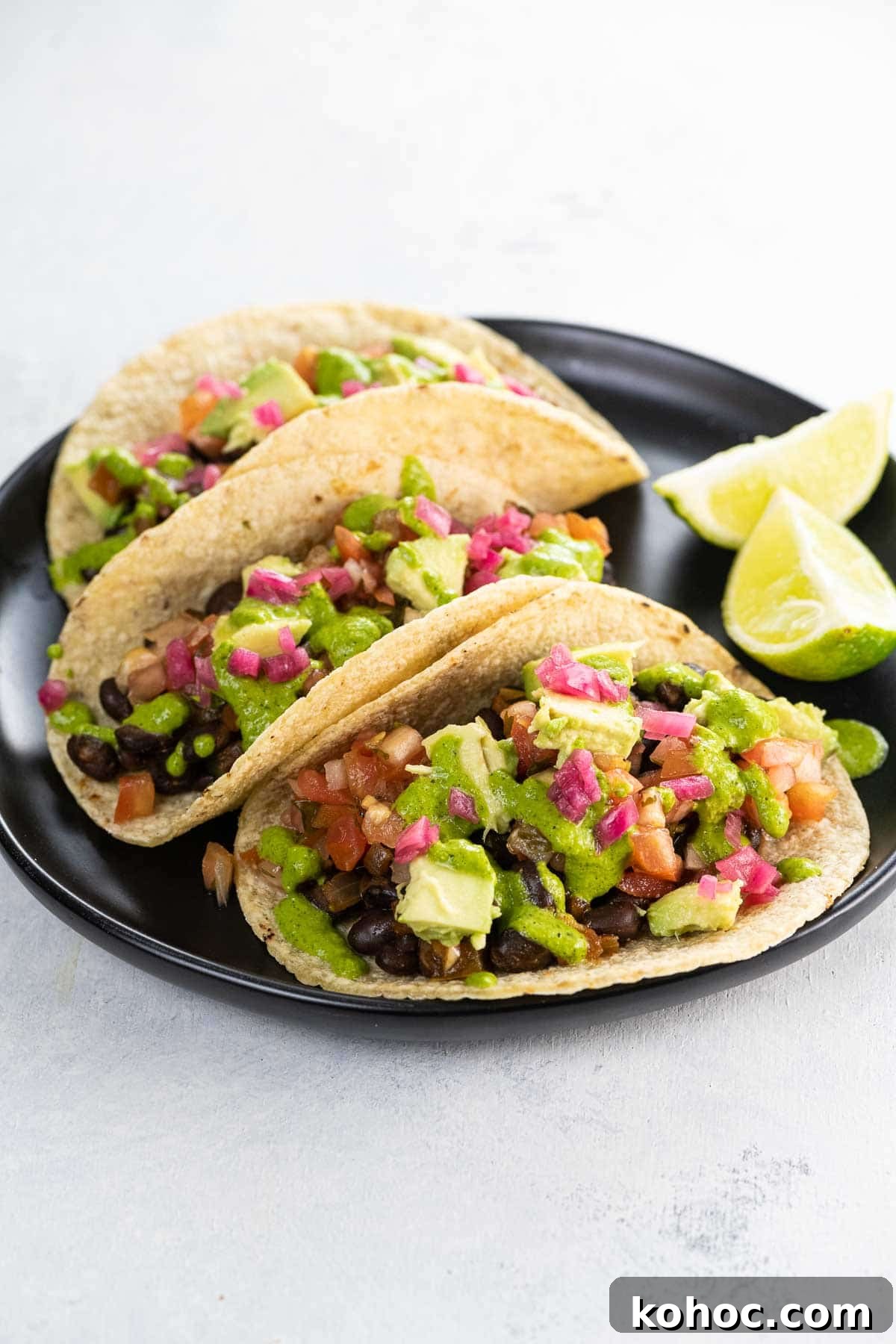 Flavorful Black Bean Vegan Tacos with Avocado Salsa 2 black bean vegan tacos on a plate