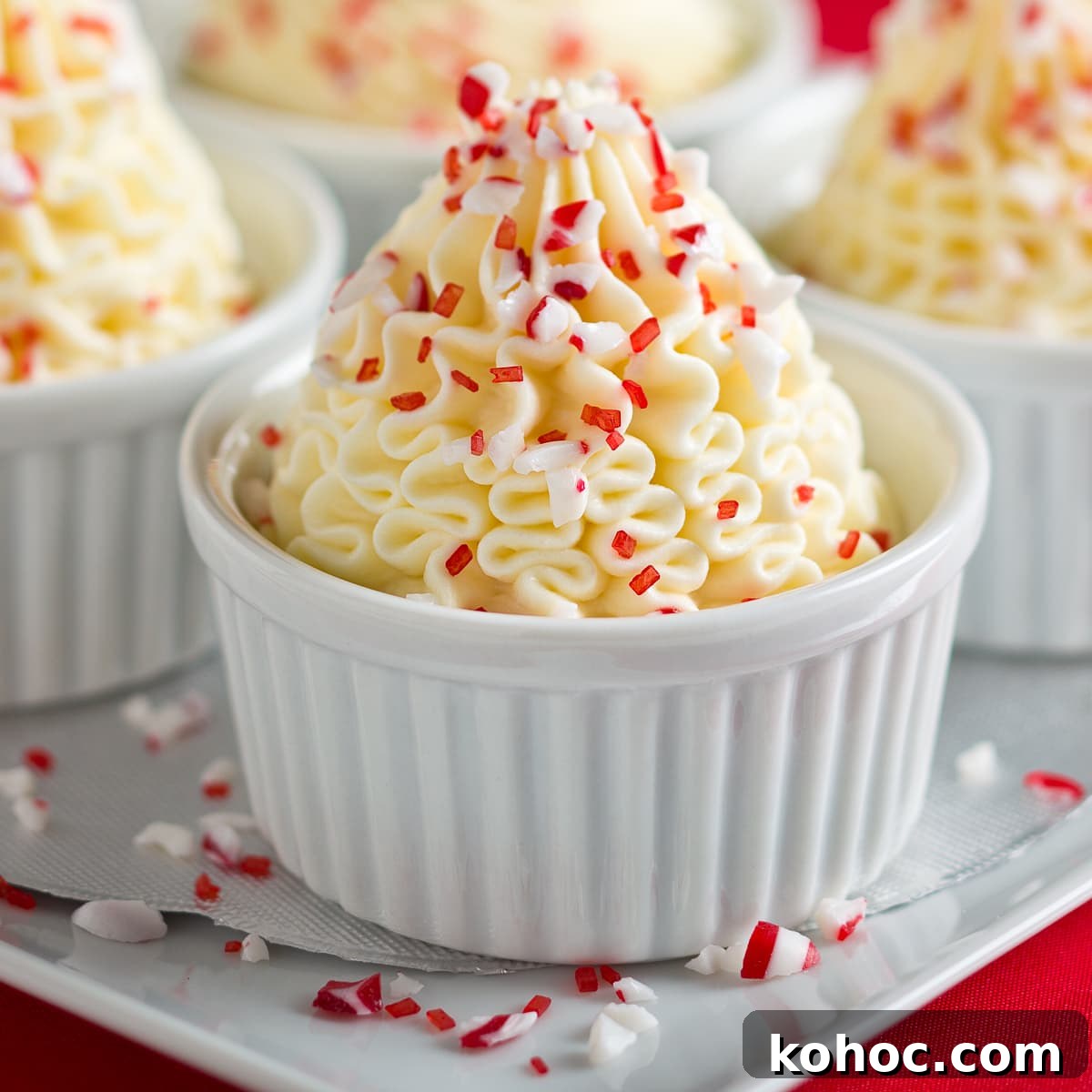 Silky White Chocolate Mousse Recipe: Step-by-Step Guide 2 White chocolate peppermint mousse in white ramekins sprinkled with crushed peppermints.