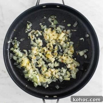 Sautéed onion and garlic in a skillet with red pepper flakes.