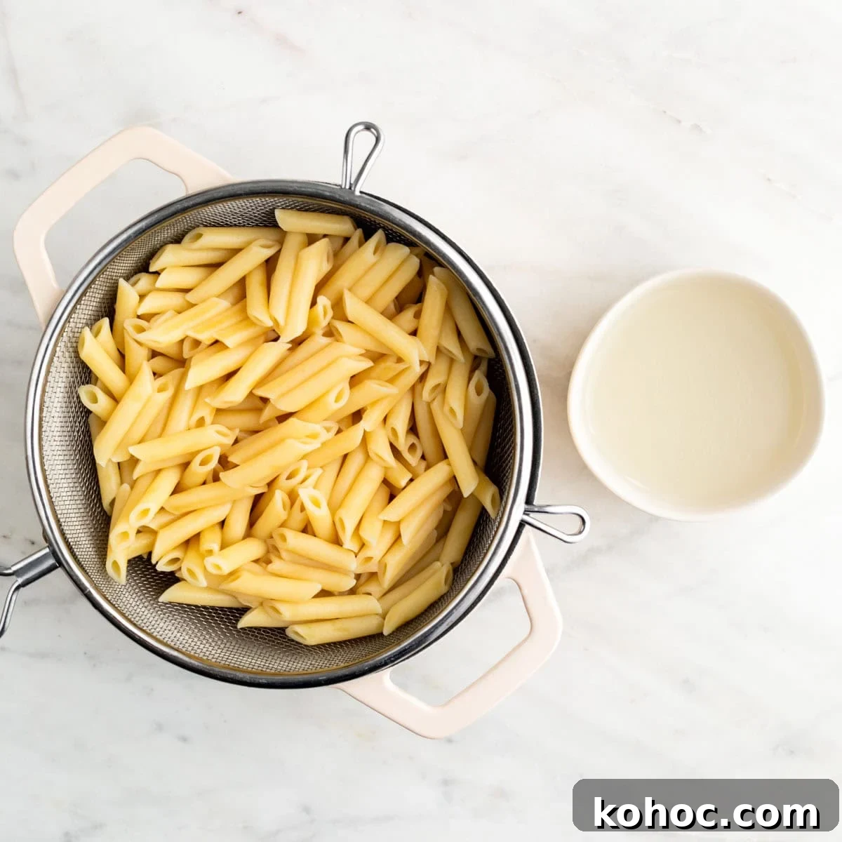 Cooked pasta in a pot and reserved pasta water in a bowl.