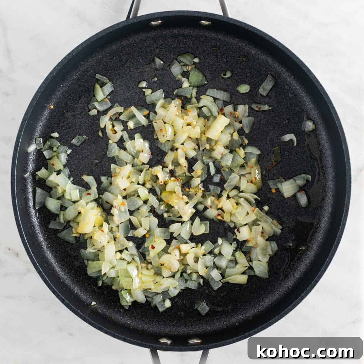 Sautéed onion and garlic in a skillet with red pepper flakes.