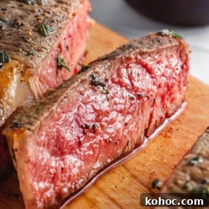 30 High-Protein Dinner Recipes for Muscle & Weight Goals 13 Juicy ribeye steak slices on a cutting board.