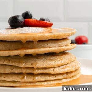 30 High-Protein Dinner Recipes for Muscle & Weight Goals 8 A stack of pancakes drizzled with syrup and topped with berries.