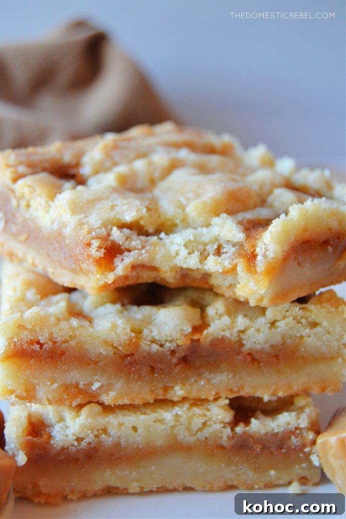 Salted Caramel Butter Bars Recipe with Buttery Shortbread Crust 7 a trio stack of salted caramel butter bars. the top bar has a bite missing from it.