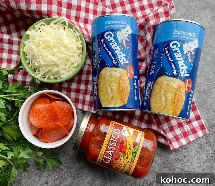 Bubble-Up Biscuit Pizza Casserole Recipe for Family Nights 4 Ingredients needed to make an easy pizza casserole including refrigerated buttermilk biscuits, pizza sauce, cheese and pepperoni.