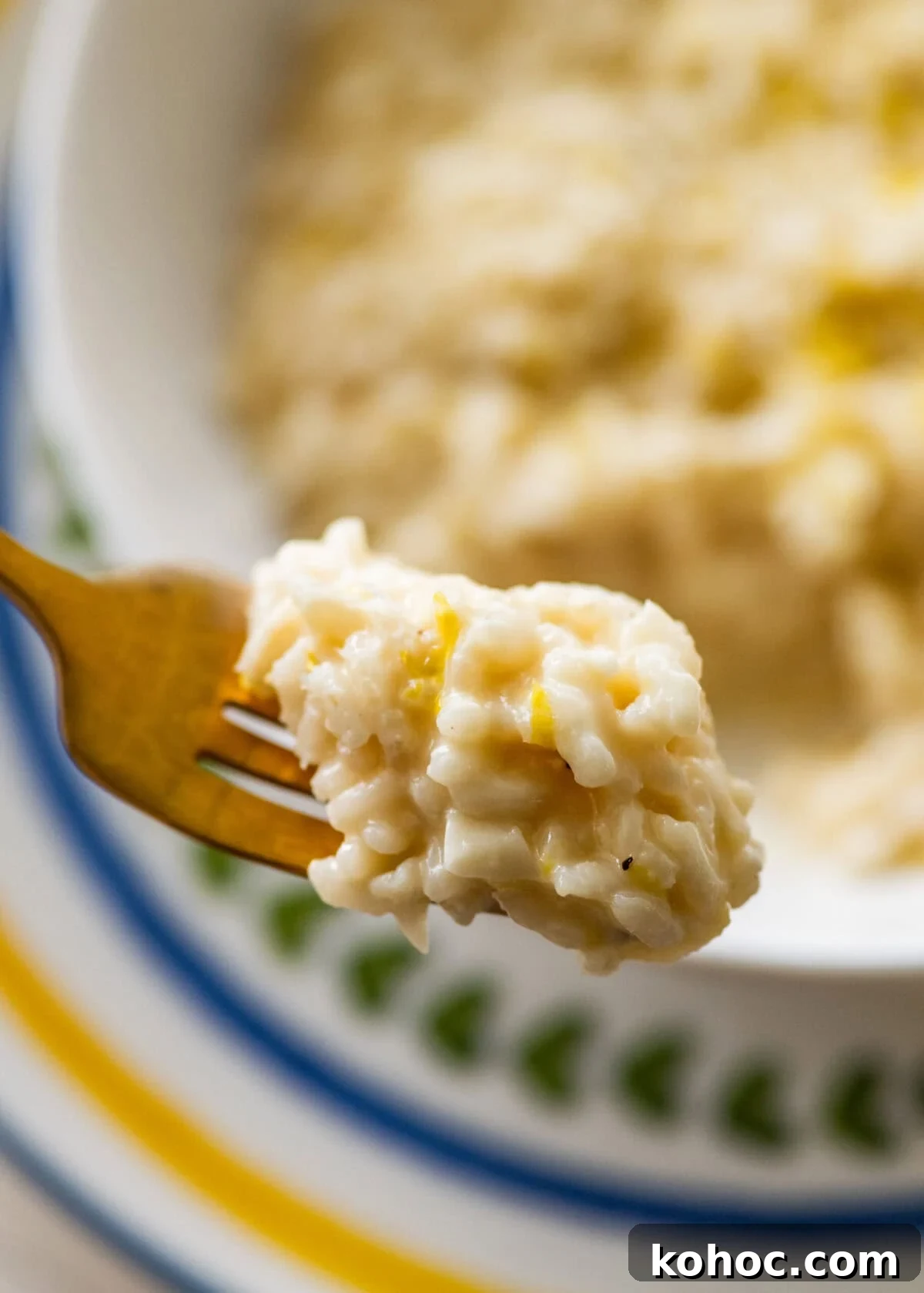 Creamy Lemon Risotto with Parmesan and Fresh Herbs 14 One bite of lemon risotto on a fork held over a bowl of more risotto.
