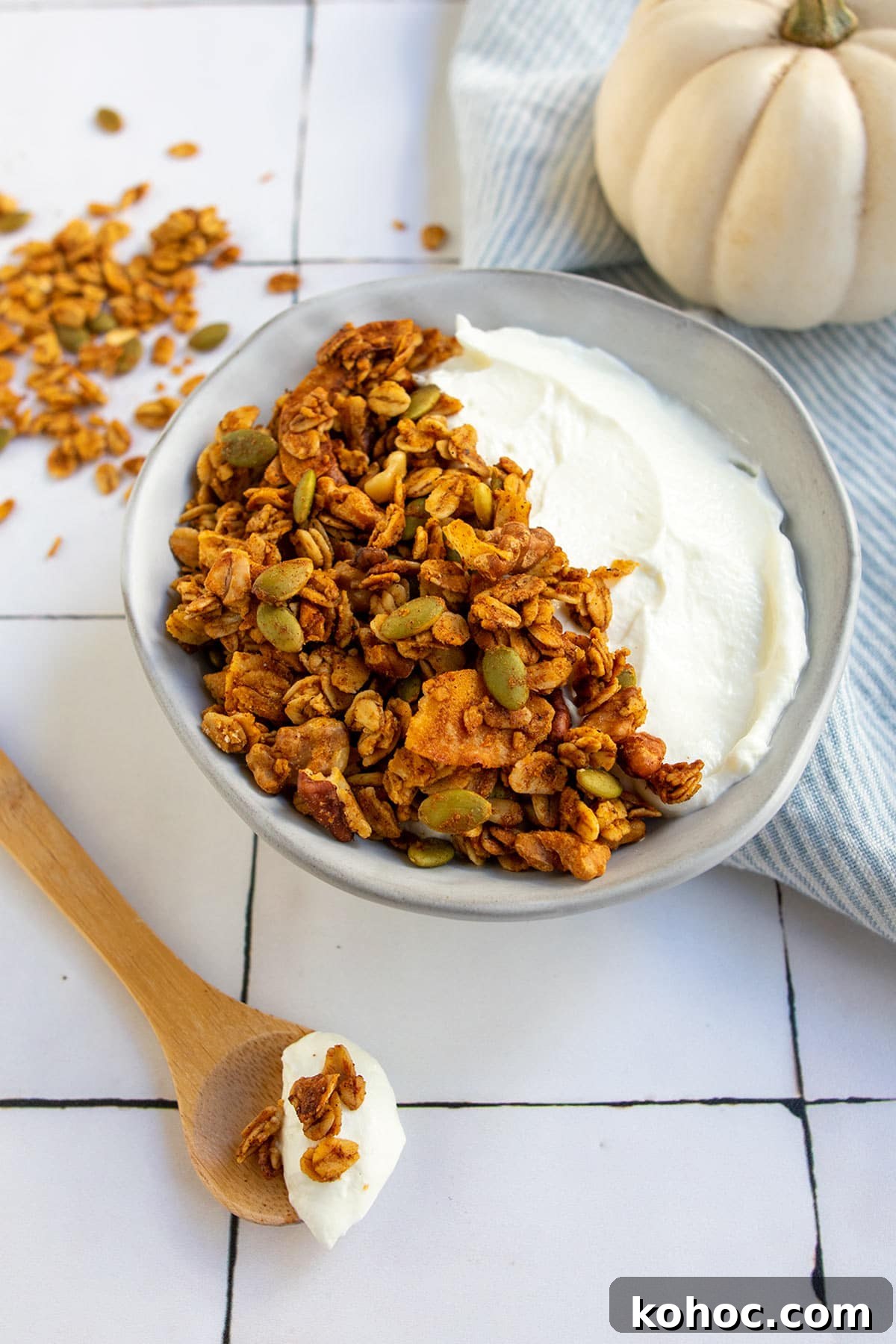 Pumpkin Granola with Maple or Date Syrup 4 Yogurt and granola in grey bowl with white pumpkin and wooden spoon.