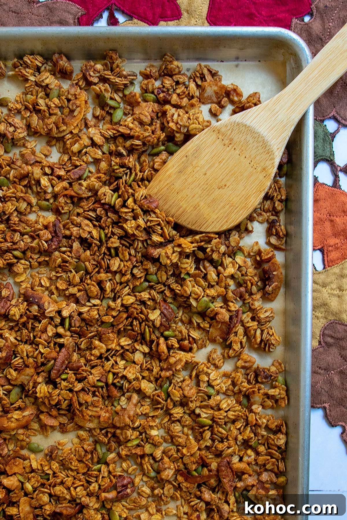 Pumpkin Granola with Maple or Date Syrup 10 Baked granola on sheet tray with wooden mixing paddle.