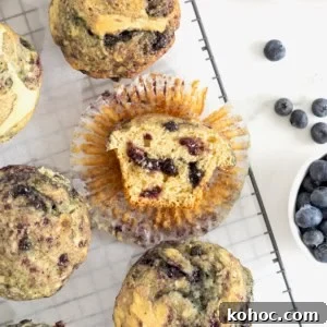 Six blueberry swirl muffins on a wire cooling rack.
