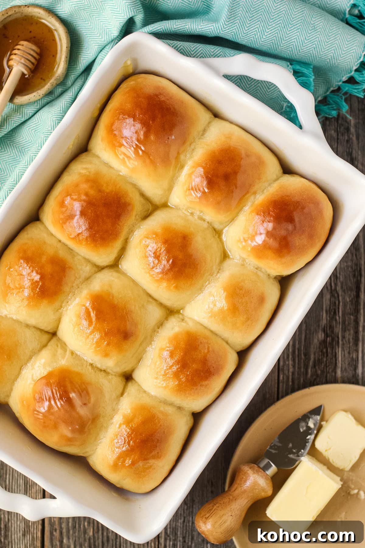 One-Hour Soft and Fluffy Dinner Rolls 8 honey butter yeast rolls in a white baking dish