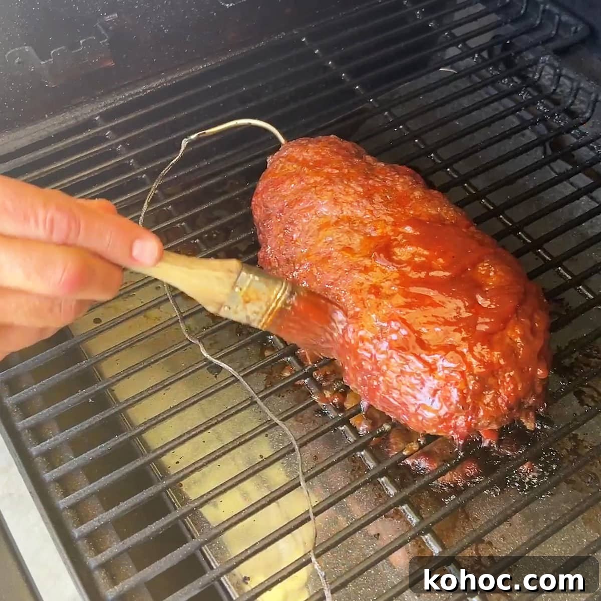 Smoked Meatloaf Recipe for Pellet Grills: Juicy, Flavorful Slice 13 Brushing barbecue sauce and ketchup on the outside as the meatloaf cooks.