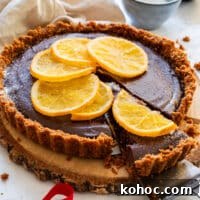 Decadent Chocolate Orange Tart Recipe with Zesty Ganache 11 Lifted slice of chocolate orange tart showing thick ganache filling and crumb crust.