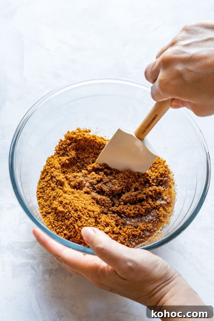Decadent Chocolate Orange Tart Recipe with Zesty Ganache 4 Mixing crushed Biscoff cookies with melted butter for the tart crust.