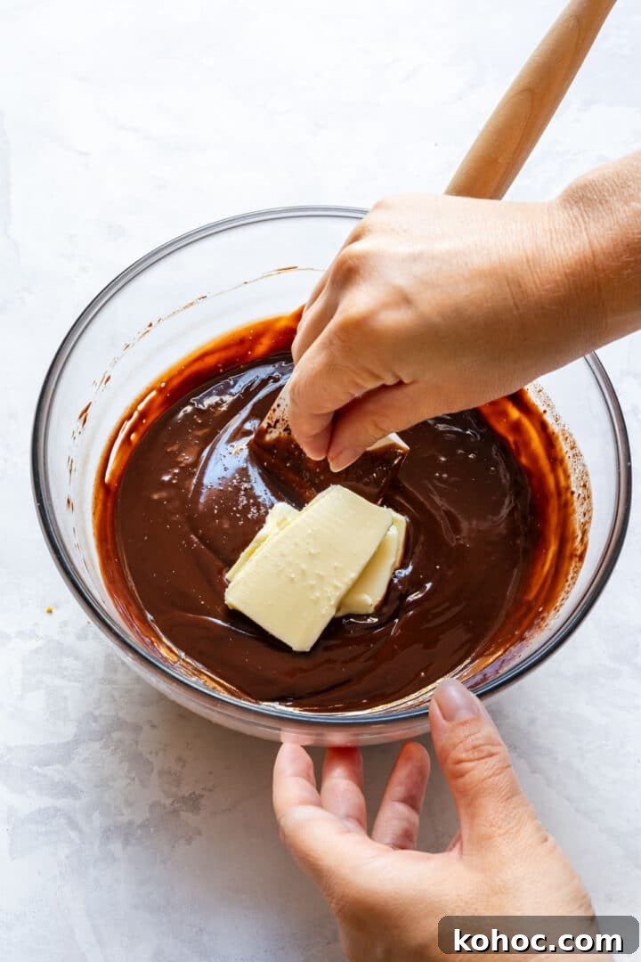 Decadent Chocolate Orange Tart Recipe with Zesty Ganache 7 Stirring chocolate ganache with butter until smooth.