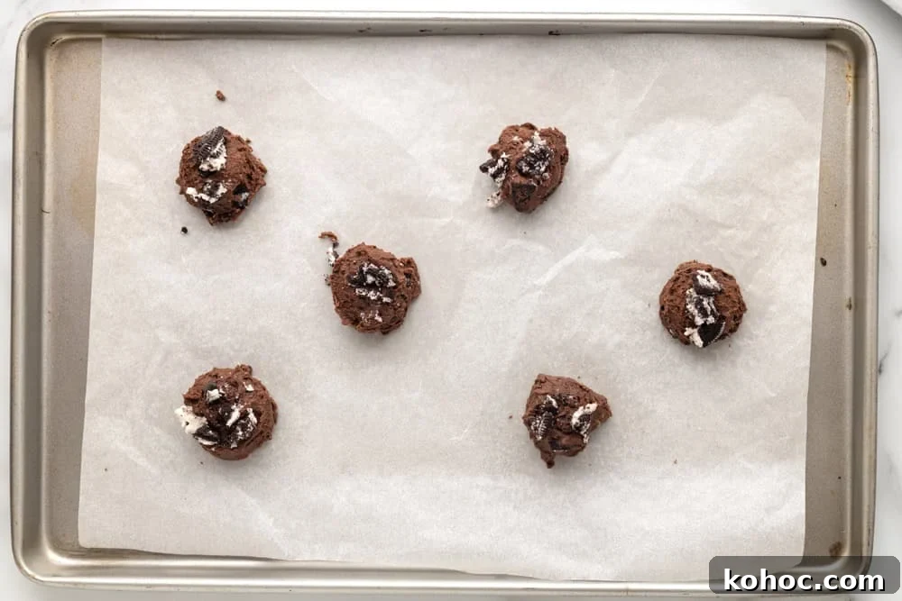 Oreo Brownie Mix Cookie Recipe — Fudgy Oreo Cookies 13 Oreo brownie cookie dough balls lined up in a baking tray lined with parchment.