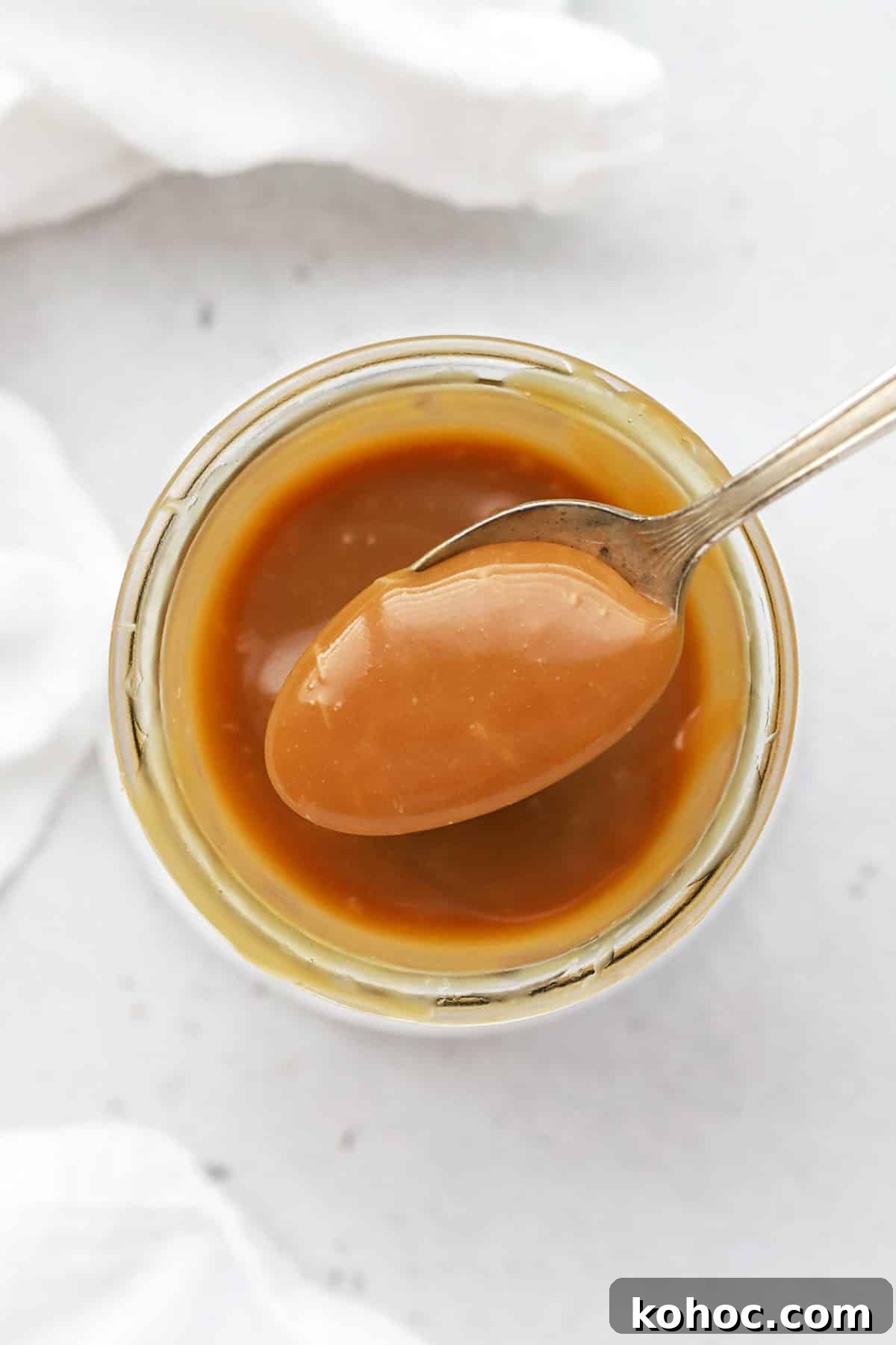 Homemade Caramel Sauce Recipe for Drizzling and Desserts 2 Scooping a spoonful of easy caramel sauce