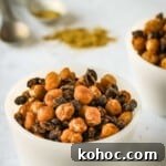 Side shot of two white bowls of chickpeas and black beans with spices and measuring cups in the background.