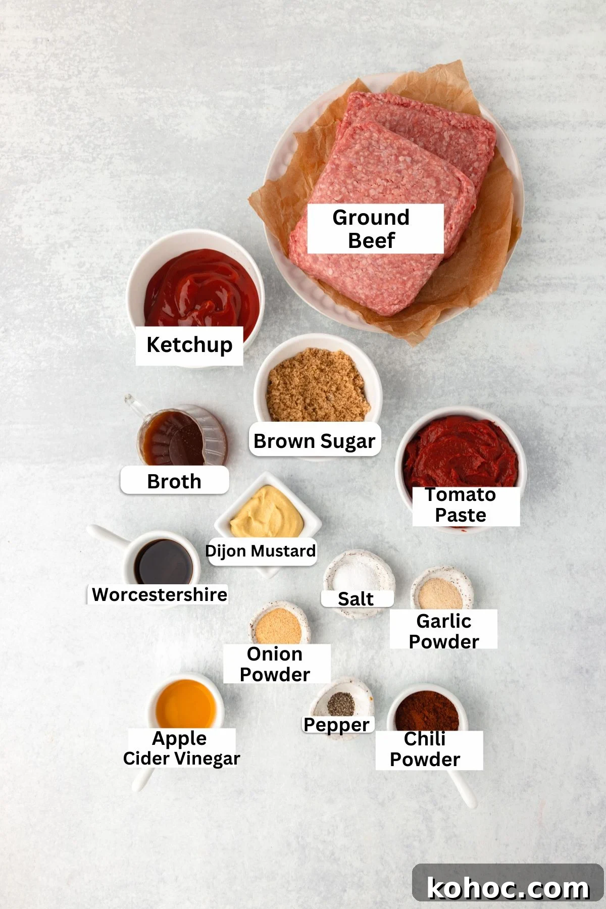 Slow-Cooker Sloppy Joes Recipe for Tender, Saucy Sandwiches 3 Top-down view of labeled ingredients for a recipe, including ground beef, ketchup, brown sugar, tomato paste, broth, Dijon mustard, Worcestershire, seasonings, and apple cider vinegar, arranged on a light surface.