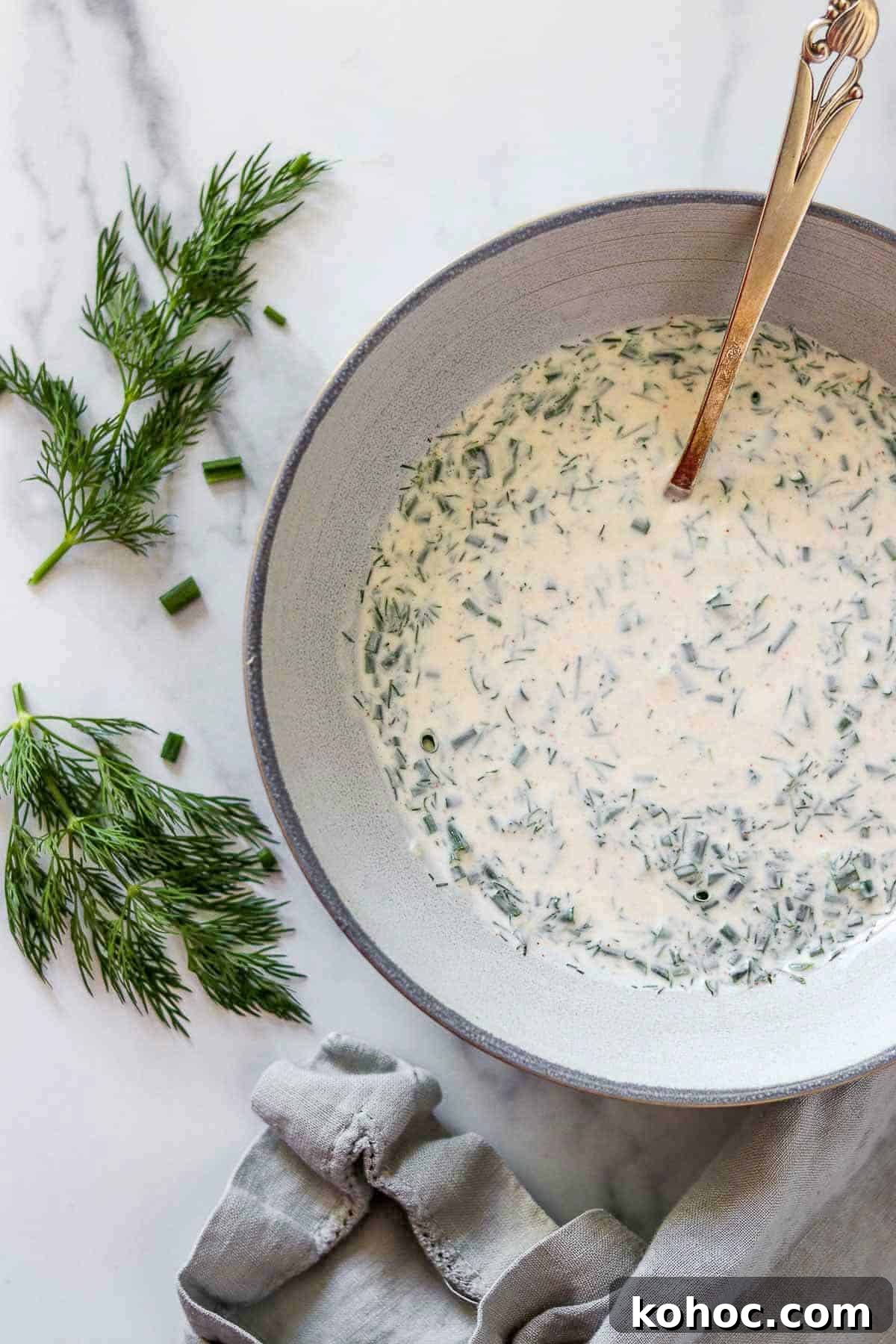 Hearty Savory Barley Breakfast Bowls for Morning Protein 4 Creamy Herbed Skyr Sauce in a bowl with a spoon next to fresh herbs.