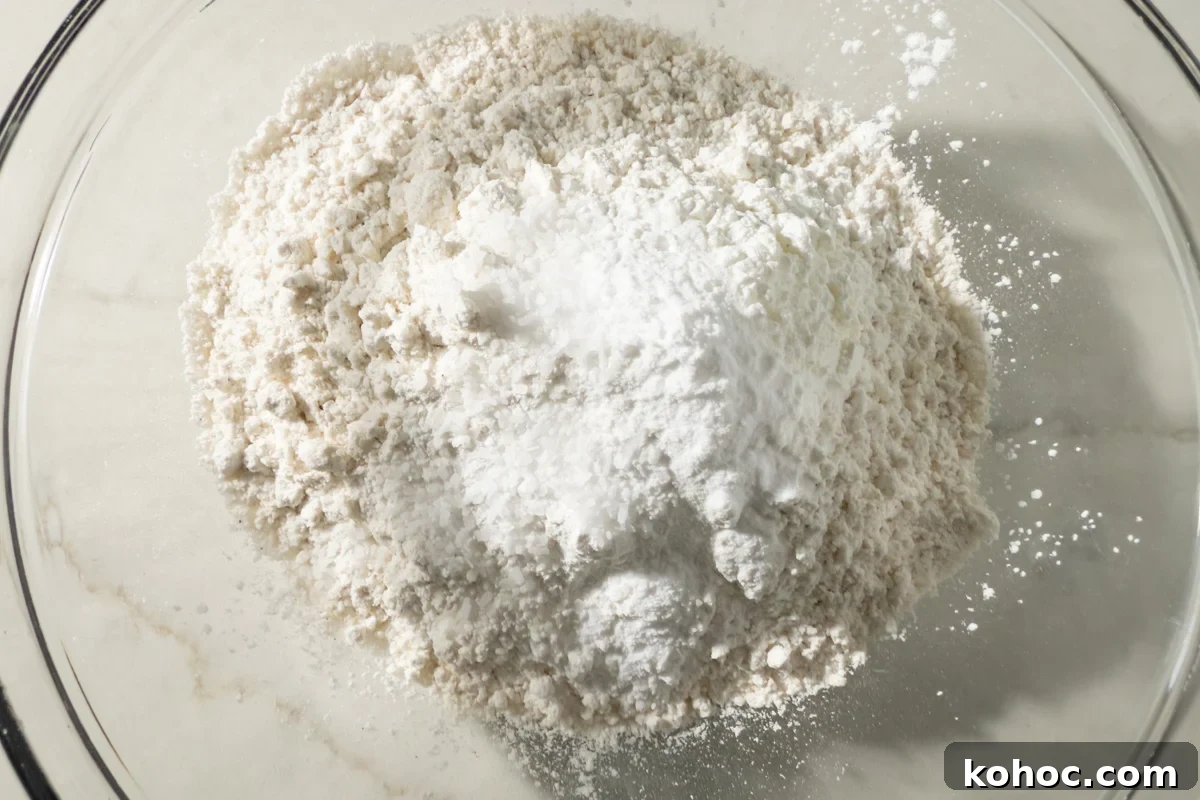 Gluten-Free Cookie Cake Recipe — Soft, Chewy Dessert Cake 7 Bowl of gluten-free flour, baking soda, salt, and cornstarch ready to be whisked together.