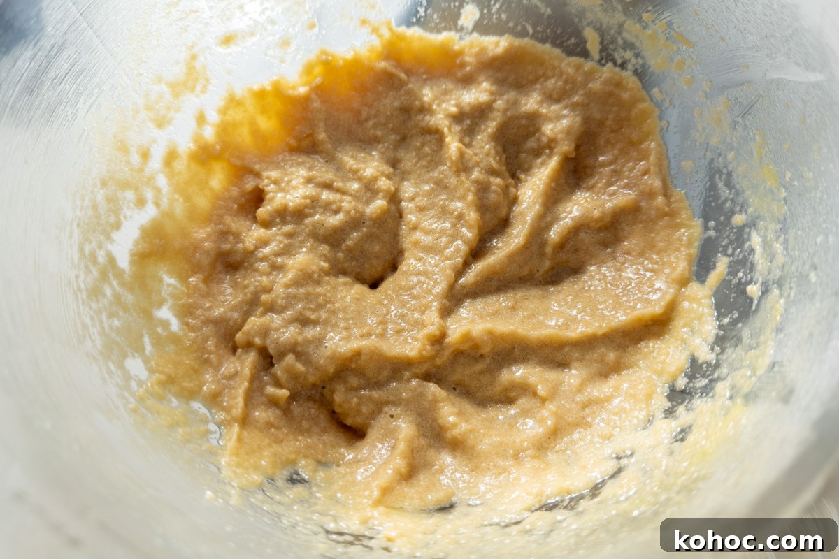Gluten-Free Cookie Cake Recipe — Soft, Chewy Dessert Cake 9 Wet ingredients combined in a mixing bowl before adding dry ingredients to form cookie dough.