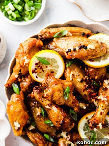 honey lemon chicken wings in a bowl with green onions