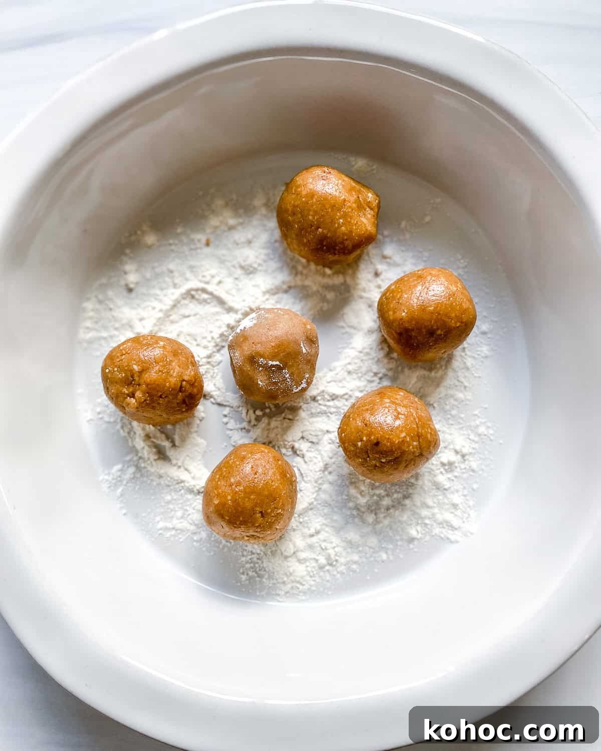 process shot showing rolling peanut butter balls in flour