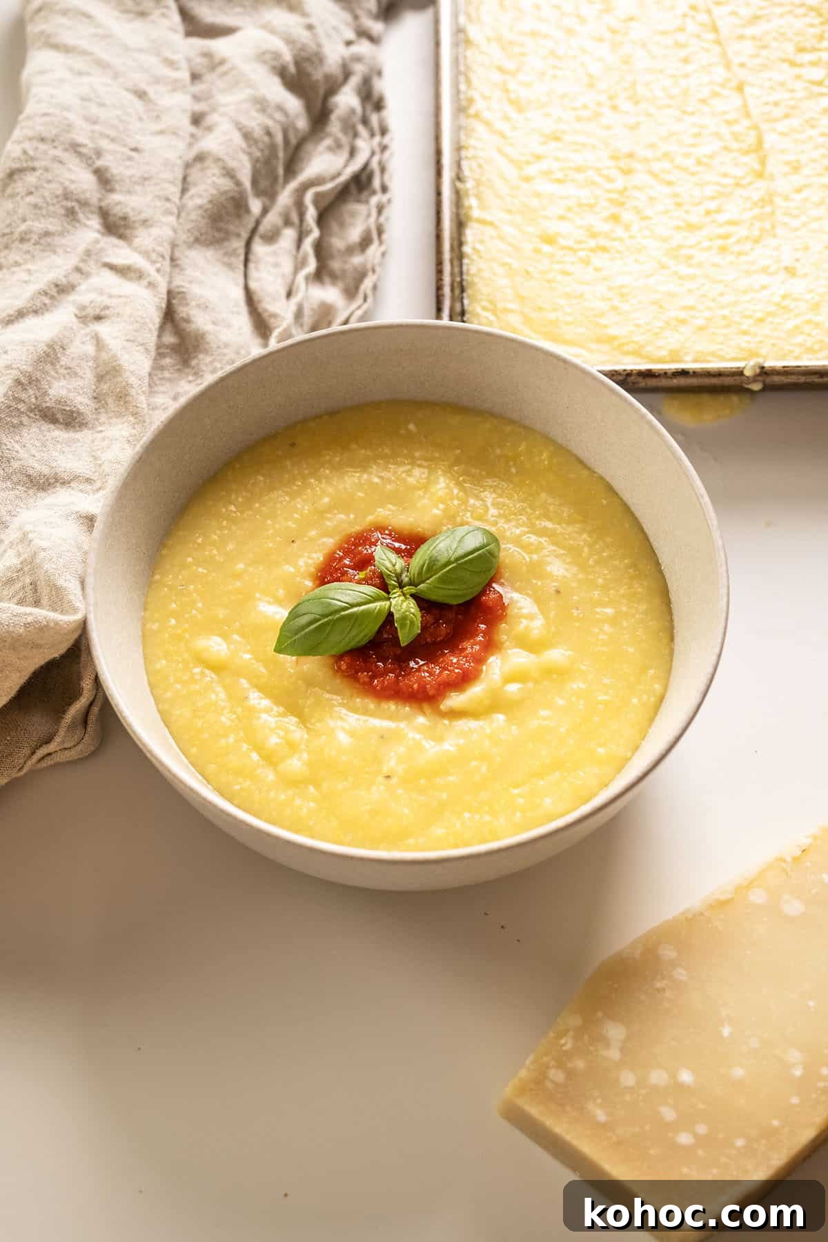 Creamy Italian Polenta Recipe 8 Creamy polenta in a bowl topped with marinara and basil.