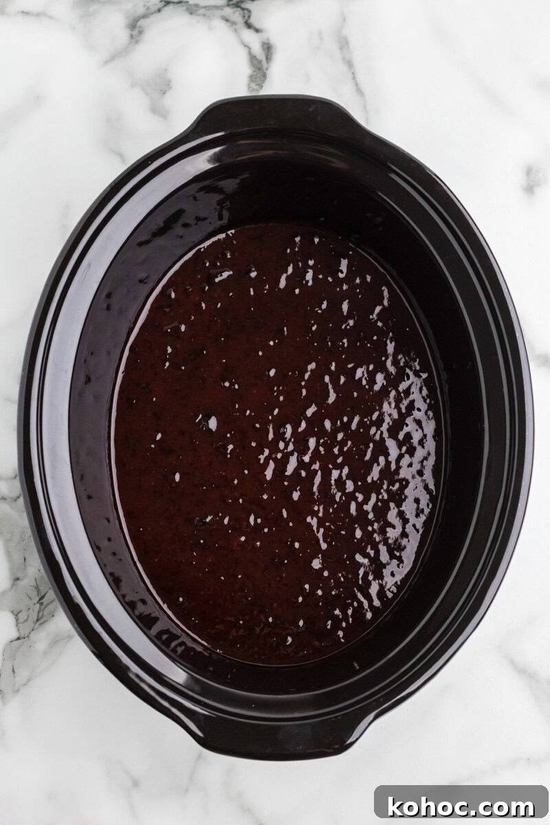 Quick 3-Ingredient Meatball Recipe for Busy Weeknights 5 grape jelly and BBQ sauce in the bottom of the slow cooker.