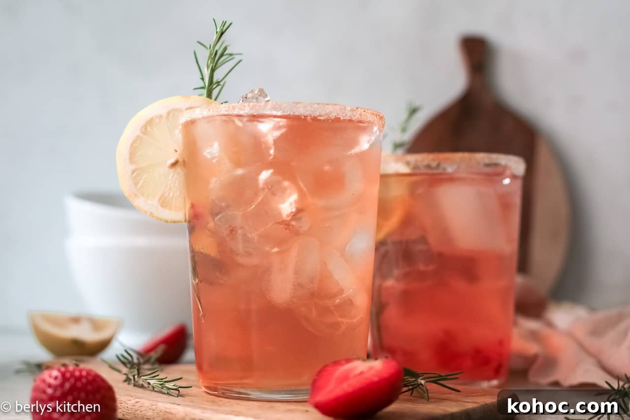 Two glasses of strawberry cocktail with lemon slice.
