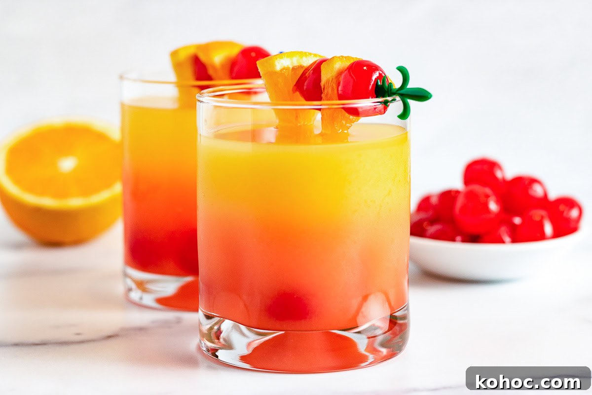 Two glasses of malibu sunset with cherries.