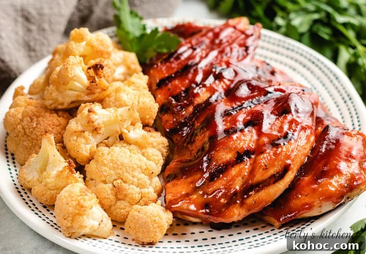 Grilled chicken with bbq sauce next to cauliflower.